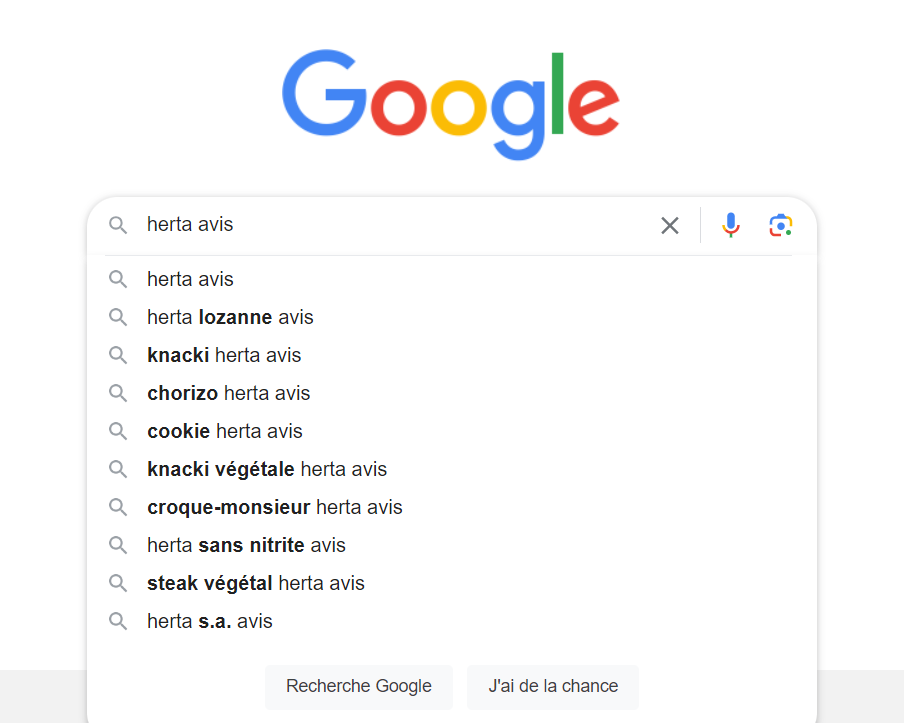 L'image montre un écran d'ordinateur avec une fenêtre de navigateur ouverte sur la page d'accueil de Google. La barre de recherche de Google contient le texte "herta avis". En dessous, il y a une liste de recherches associées, qui incluent "herta avis", "herta lozanne avis", "knacki herta avis", "chorizo herta avis", "cookie herta avis", "knacki végétale herta avis", "croque-monsieur herta avis", "herta sans nitrite avis", "steak végétal herta avis", et "herta s.a. avis". Au bas, il y a les boutons "Recherche Google" et "J'ai de la chance".