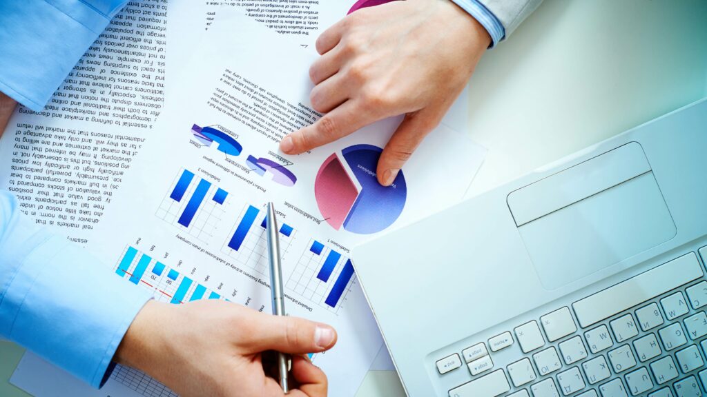 Analyse de données concurrentielle avec graphiques et diagrammes circulaires montrant la performance de l'entreprise sur un bureau avec ordinateur portable.