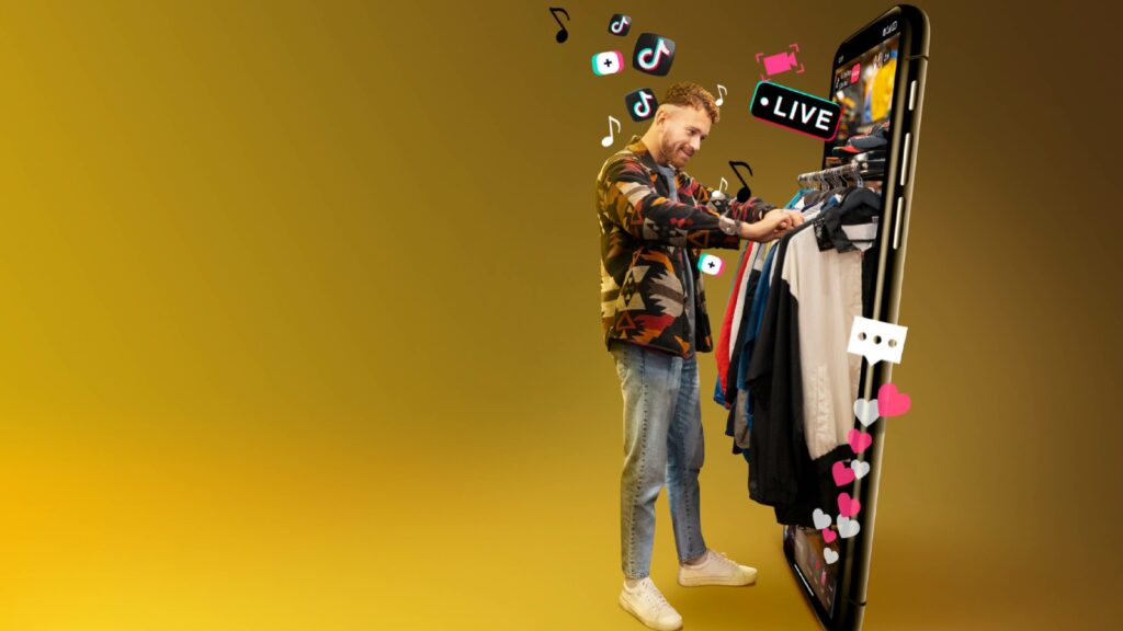 Un homme souriant sélectionnant des vêtements à partir d'un grand écran de smartphone géant avec des icônes TikTok et des cœurs flottants, symbolisant les achats en direct et l'engagement sur la plateforme.